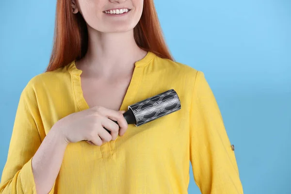 Νεαρή Γυναίκα Καθαρισμού Ρούχα Ρολό Χνούδι Γαλάζιο Φόντο Closeup — Φωτογραφία Αρχείου