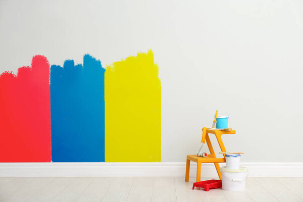 Decorator's kit of tools and paints near light wall indoors 