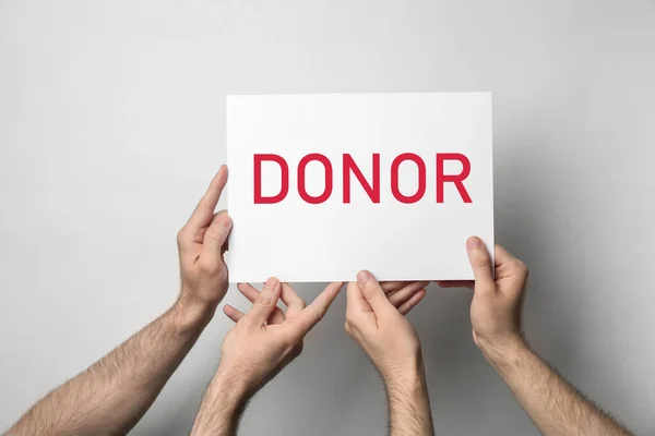 Mannen Met Naamkaartje Donor Lichte Achtergrond Close — Stockfoto