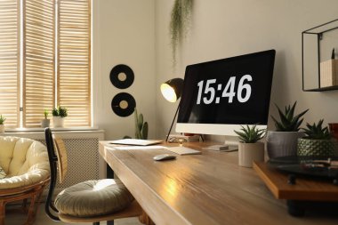 Rahat işyeri olan bir oda. Ahşap masadaki modern bilgisayar