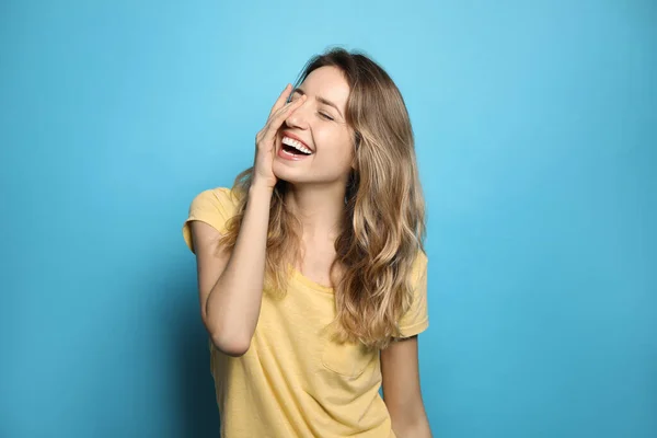Fröhliche Junge Frau Lacht Auf Hellblauem Hintergrund — Stockfoto