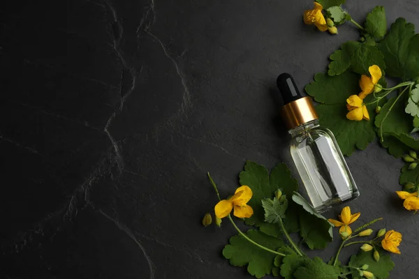 一壶天然西兰花油和花放在黑桌上 平铺着 案文的篇幅 — 图库照片