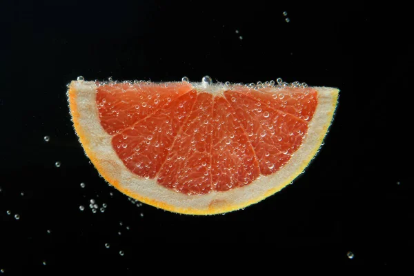 Grapefruitscheiben Sprudelndem Wasser Auf Schwarzem Hintergrund Zitrusfrüchte — Stockfoto