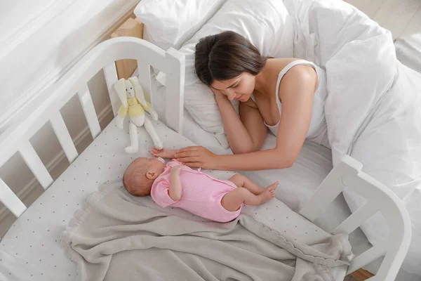 Jovem Mãe Descansando Perto Berço Com Bebê Recém Nascido Adormecido — Fotografia de Stock