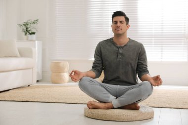 Adam evde hasır üzerinde meditasyon yapıyor. Metin için boşluk
