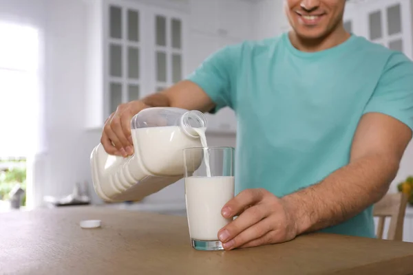 Hombre Vertiendo Leche Botella Galón Vidrio Mesa Madera Cocina Primer — Foto de Stock