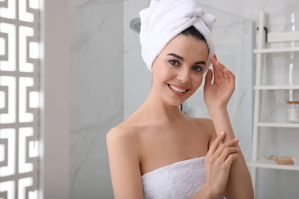 快乐的年轻女人头上拿着毛巾在浴室里 文字的空间 — 图库照片