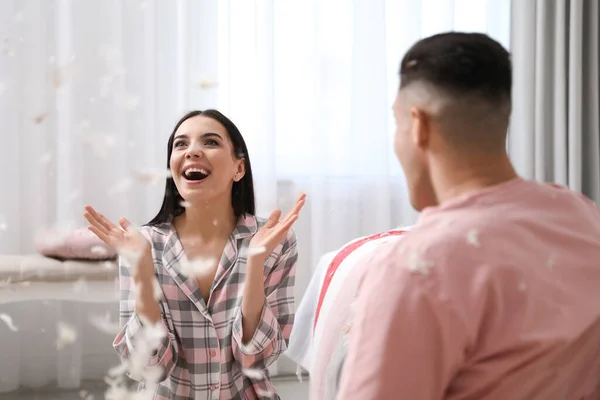 Pareja Feliz Divirtiéndose Con Plumas Voladoras Después Pelea Almohadas Dormitorio — Foto de Stock