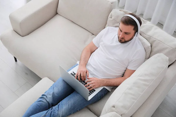 Hombre Con Portátil Auriculares Sentado Sofá Casa — Foto de Stock