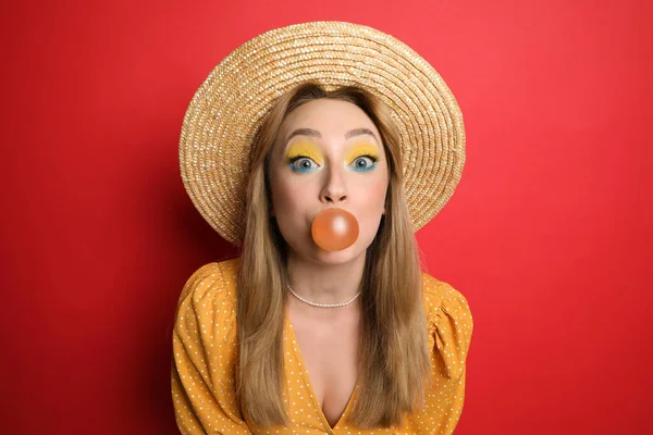 Mulher Nova Moda Com Maquiagem Brilhante Soprando Bubblegum Fundo Vermelho — Fotografia de Stock