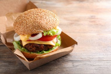 Tahta masadaki karton kutuda nefis bir burger.