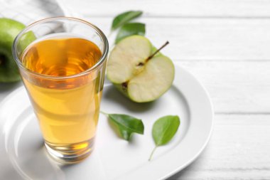 Beyaz ahşap masada bir bardak taze elma suyu, yakın plan. Metin için boşluk