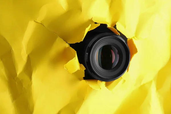 黄色い紙の穴を通ってスパイ隠しカメラテキストのためのスペース — ストック写真