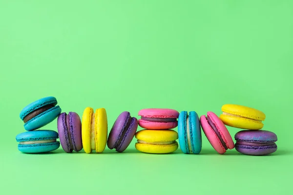 Deliciosos Macarrones Coloridos Sobre Fondo Verde Espacio Para Texto — Foto de Stock