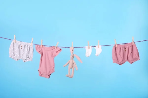 ターコイズを背景に洗濯物を干しているきれいな子供の服 — ストック写真