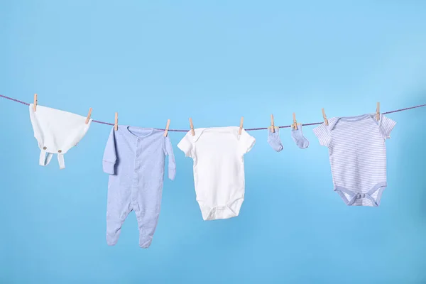 Temiz Çocuk Giysileri Açık Mavi Arka Planda Çamaşır Ipine Asılı — Stok fotoğraf