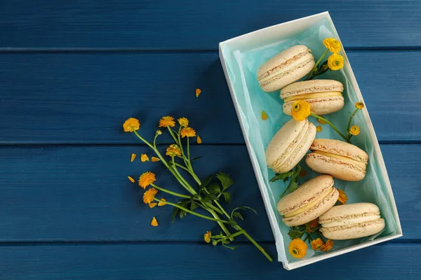 Deliciosos Macarones Flores Mesa Madera Azul Puesta Plana —  Fotos de Stock