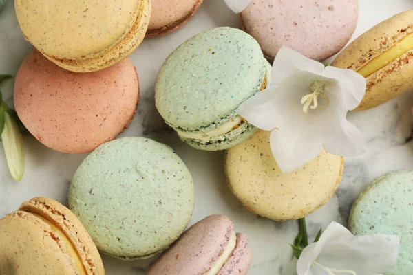 Köstliche Macarons Und Blumen Auf Weißem Marmortisch Nahaufnahme — Stockfoto