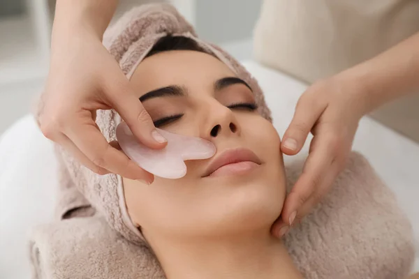 Mujer Joven Recibiendo Masaje Facial Con Herramienta Gua Sha Salón — Foto de Stock