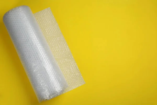 Bubble Wrap Roll Yellow Background Top View Space Text — Stock Photo, Image