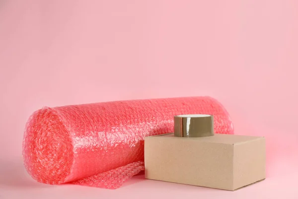 Bubble Wrap Roll Teippi Pahvilaatikko Vaaleanpunaisella Taustalla Tilaa Tekstille — kuvapankkivalokuva