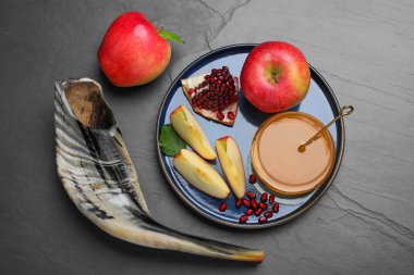 Bal, nar, elma ve Shofar siyah masada, düz yerde. Rosh Hashana tatili