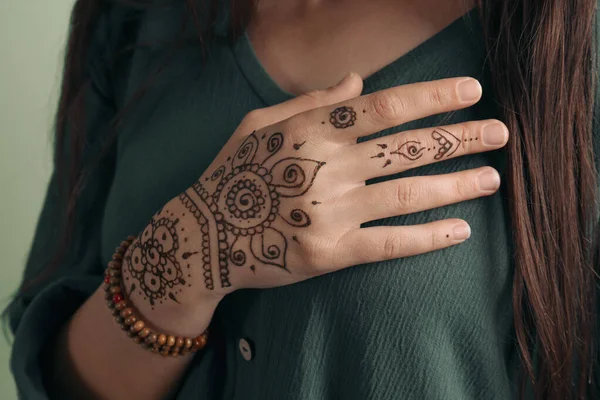 Vrouw Met Mooie Henna Tattoo Bij Hand Tegen Groene Achtergrond — Stockfoto
