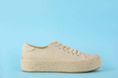 Açık mavi arka planda şık, rahat bir ayakkabı. Metin için boşluk