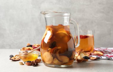 Açık gri masada kurutulmuş meyve ve malzemelerle enfes bir karışım.