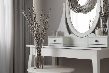 Elegant dressing table decorated with pussy willow branches indoors