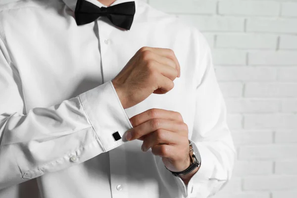 Homem Elegante Colocando Abotoaduras Perto Parede Tijolo Branco Close — Fotografia de Stock