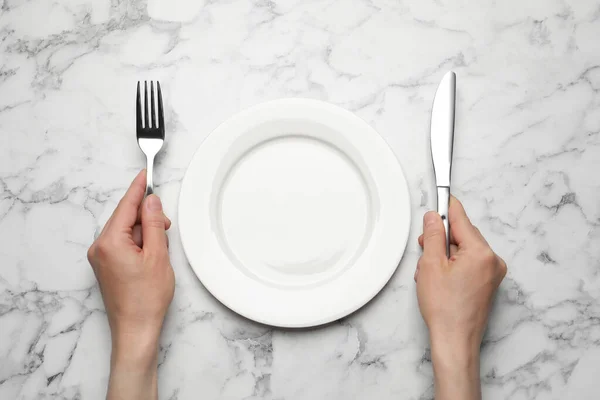 Vrouw Met Leeg Bord Bestek Aan Witte Marmeren Tafel Bovenaanzicht — Stockfoto