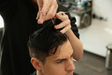 Profesyonel berber kuaförde şık saç kesimi yapıyor, yakın plan.
