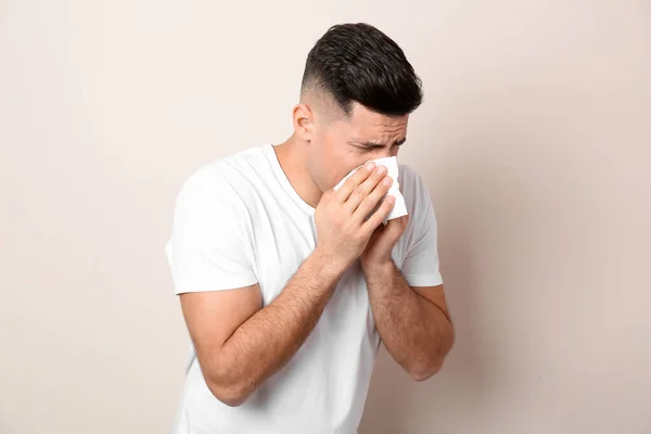 Homme Avec Des Tissus Souffrant Écoulement Nasal Sur Fond Beige — Photo