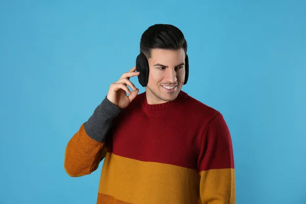 Man Wearing Stylish Earmuffs Light Blue Background — Stock Photo, Image