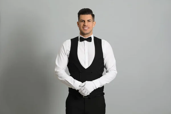 Knappe Butler Elegant Uniform Grijze Achtergrond — Stockfoto