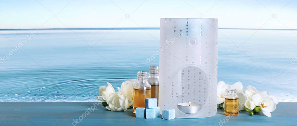 Composition with aroma lamp on blue wooden table near sea , space for text. Banner design