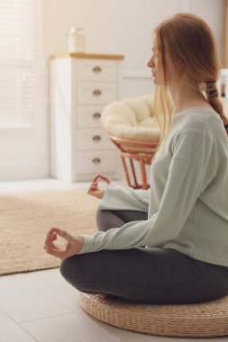 Hasır üzerinde meditasyon yapan bir kadın.