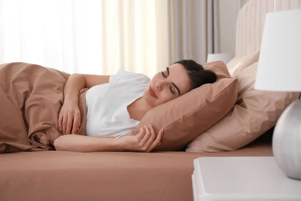 Ung Kvinna Sover Sängen Med Bruna Sängkläder Hemma — Stockfoto