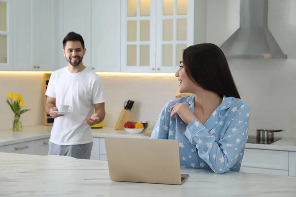 Erkek Arkadaşı Eve Kahve Getirirken Pijamalı Genç Bir Kadın Dizüstü — Stok fotoğraf