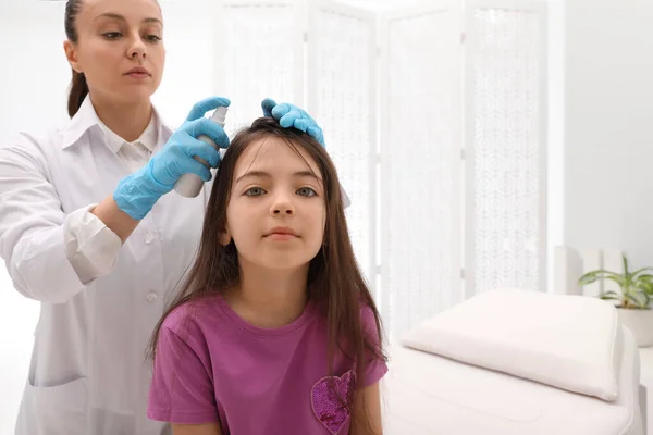 Doctor Using Lice Treatment Spray Little Girl Hair Indoors — Stock Photo, Image