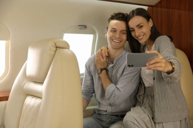 Uçakta selfie çeken sevimli genç bir çift.