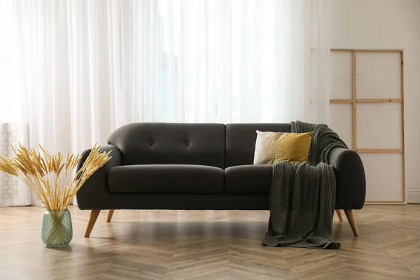 快適なグレーのソファと美しいスパイクとスタイリッシュなリビングルームのインテリア — ストック写真