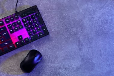 Modern RGB klavye ve fare gri masada, düz yerde. Metin için boşluk