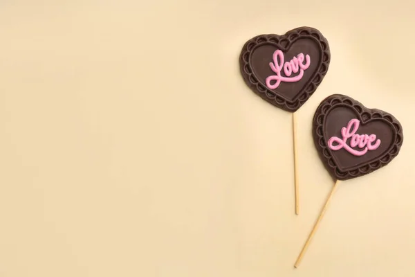 Piruletas Forma Corazón Chocolate Con Palabra Amor Sobre Fondo Beige — Foto de Stock