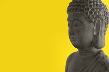 Sarı arka planda güzel taş Buda heykeli. Metin için boşluk