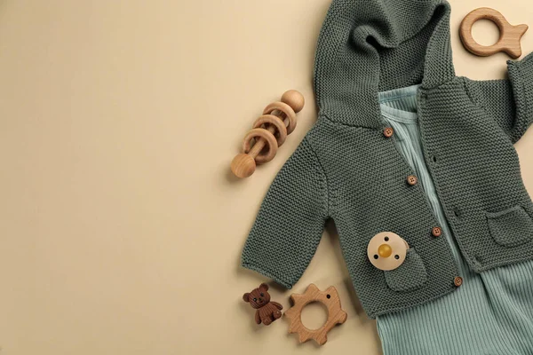 Bebek kıyafetleri ve aksesuarları olan düz konum bej arkaplan, metin için boşluk