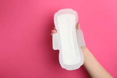 Pembe arka planda hijyenik peçete tutan kadın, yakın plan. Metin için boşluk