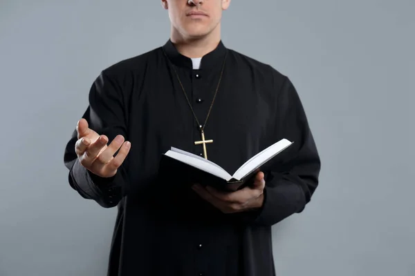Priester Met Bijbel Grijze Achtergrond Close — Stockfoto