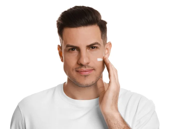 Bonito Homem Aplicando Creme Facial Fundo Branco — Fotografia de Stock